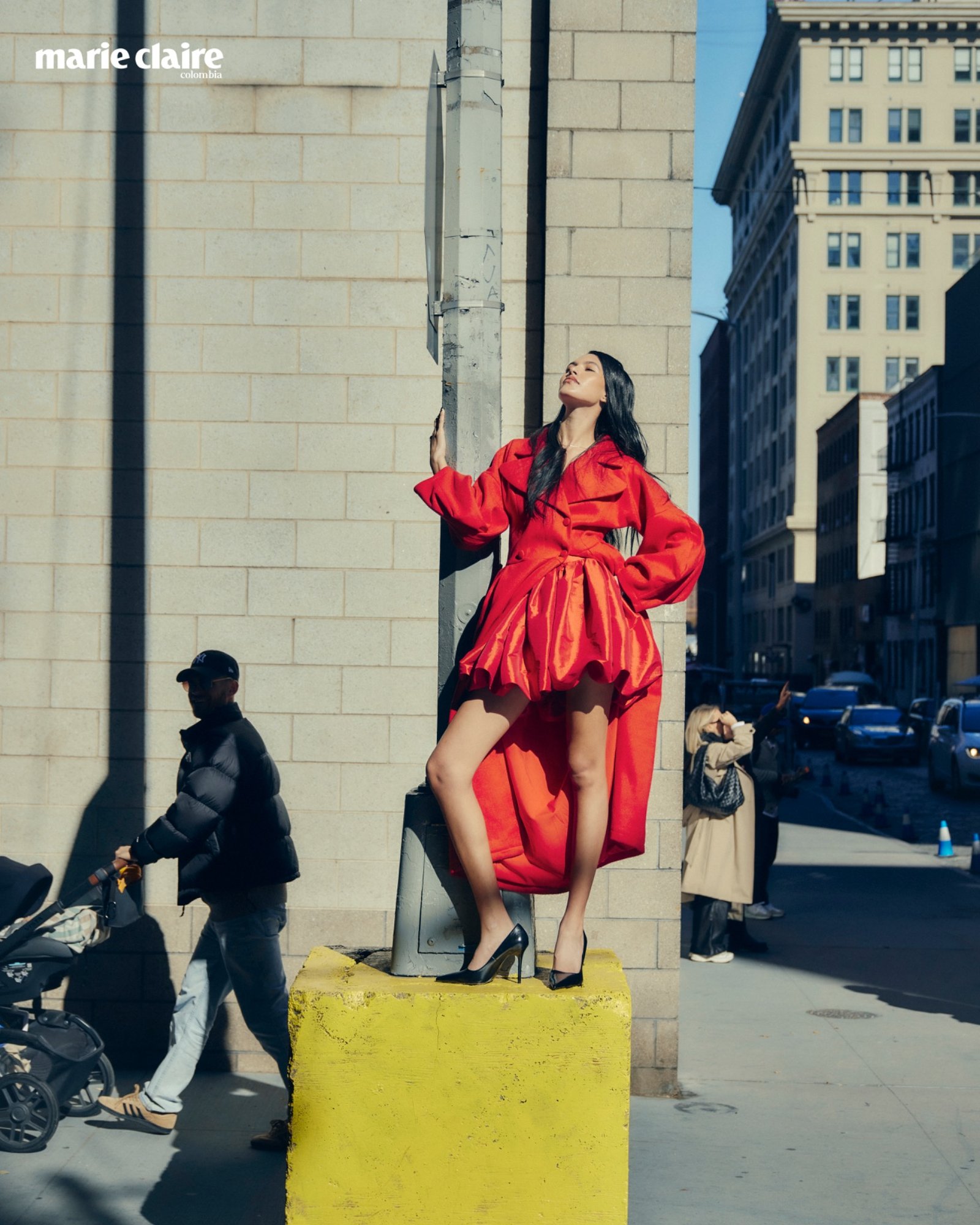 Modelo con vestido rojo junto a un taxi amarillo
