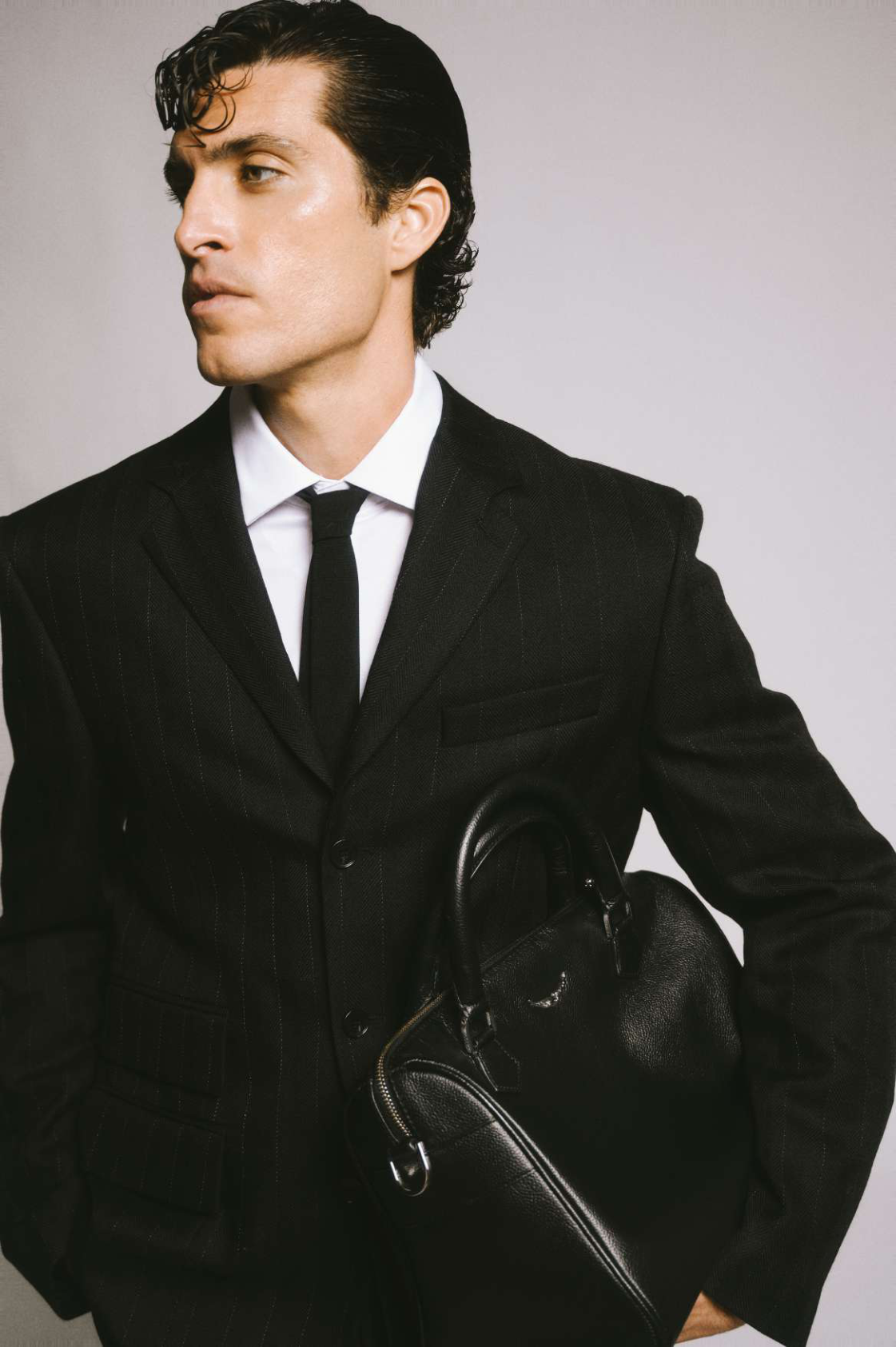The Quiet Battle: retrato editorial de modelo masculino con traje negro